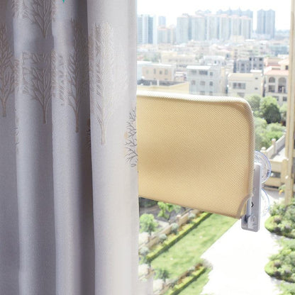 Beige plush cat window hammock mounted on glass with strong suction cups, showing city view outside window.