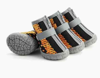Set of four lightweight, breathable pet shoes with orange and black knitted fabric and gray rubber soles for paw protection and anti-slip grip during walks.
